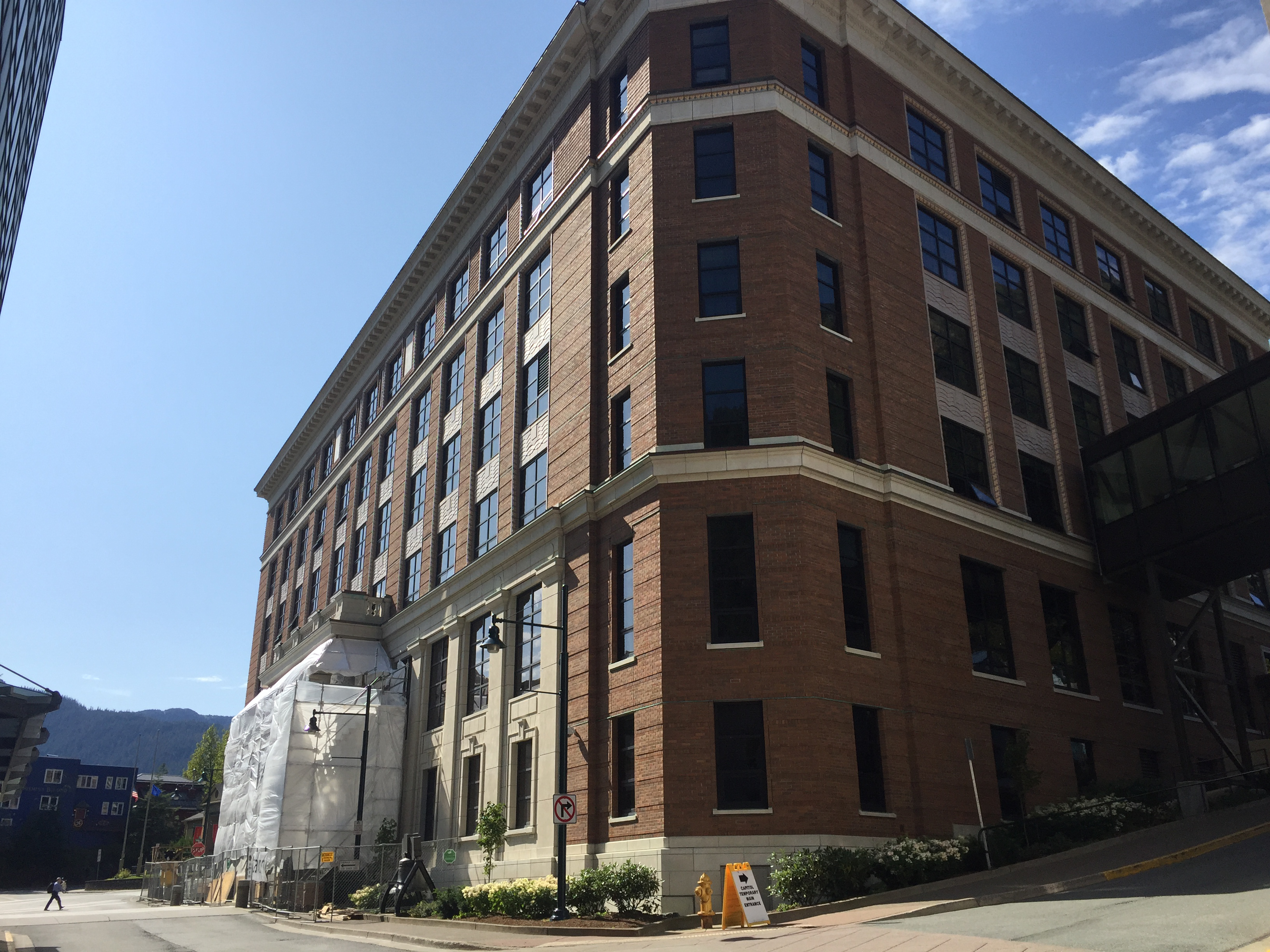 The sun shines on construction crews as they refinish the front pillars of the Capitol Building